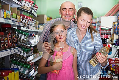 Mom with father and daughter choosing oil Stock Photo