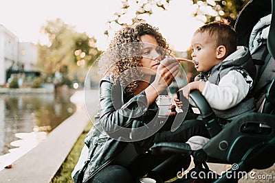 Mom feeds baby boy with a spoon Stock Photo