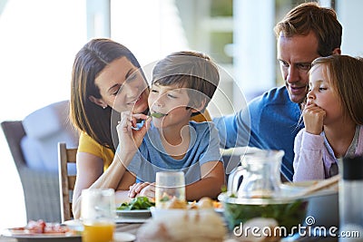 Mom only feeds her family the healthiest food. a family enjoying a meal together at home. Stock Photo