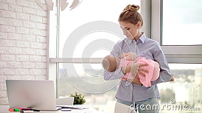 Mom holding baby on hands in office. Sleeping infant in mother embrace Stock Photo