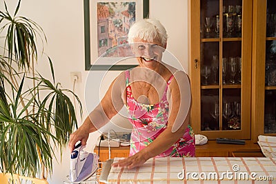 mom at home ironing with a steam iron - homemaker Stock Photo