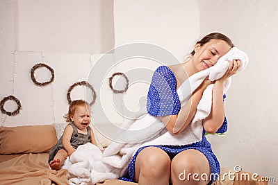 Mom imagines a sweet dream without a baby. The baby screams. The woman wants to sleep and take a break from the baby. Dreams of Stock Photo