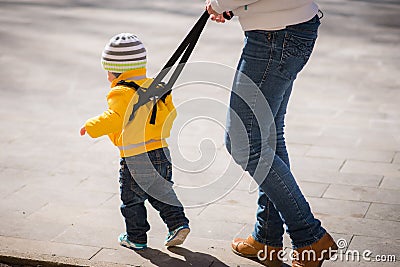 Mom insures her child during a walk Stock Photo