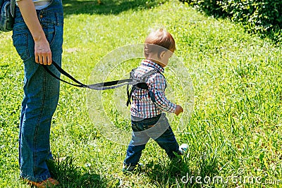 Mom insures her child during a walk Stock Photo