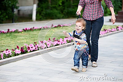 Mom insures her child during a walk Stock Photo