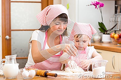 Mom and kid preparing cookies together at kitchen Stock Photo