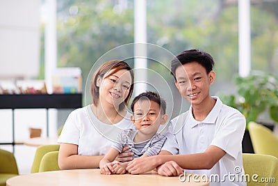 Mom and kids in restaurant. Asian family Stock Photo