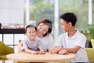 Mom and kids in restaurant. Asian family Stock Photo