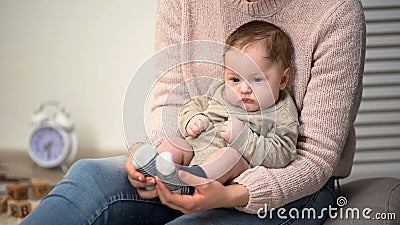 Mom massaging babys feet, method for calming fussy newborn, flatfoot prevention Stock Photo