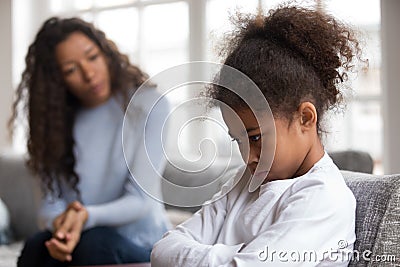 Mom or psychologist tries to talk to upset african girl Stock Photo