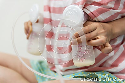 Mom pumping breastmilk into bottles Stock Photo