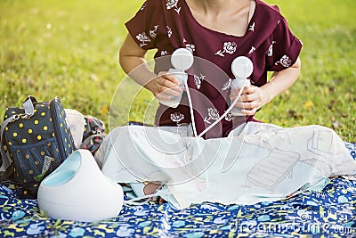 Mother pumping breastmilk in park Stock Photo