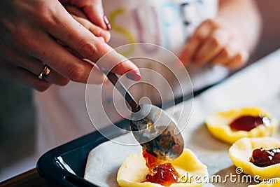 Mom`s and baby`s hands decorating cookies with a jam Stock Photo