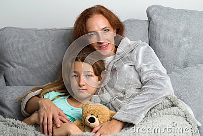 Mom sitting on couch with daughter Stock Photo