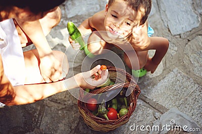 Mom and son with basket full of vegetables Stock Photo