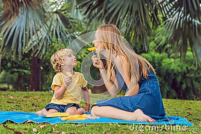 Mom and son had a picnic in the park. Eat healthy fruits - mango Stock Photo