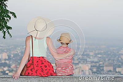 Mom and son and look at the city from a height. Rear view, evening time Stock Photo