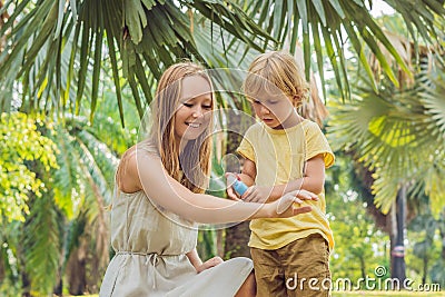 Mom and son use mosquito spray.Spraying insect repellent on skin Stock Photo
