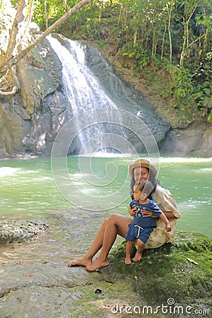 Mom and son on Wafsarak Waterfall on Biak Island Stock Photo