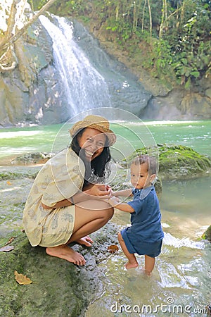 Mom and son on Wafsarak Waterfall on Biak Island Stock Photo