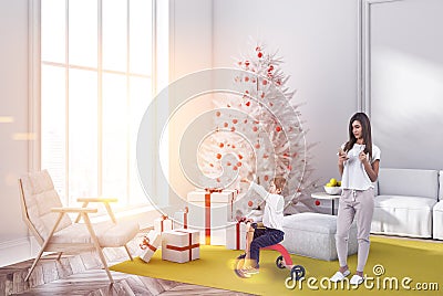 Mom and son in white living room, fir tree, gifts Stock Photo
