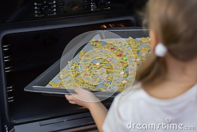 Mom teaches her daughters to cook in the kitchen. The family bakes cookies in the oven Stock Photo