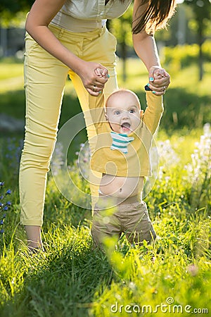 Mom teaches son walking grass Stock Photo