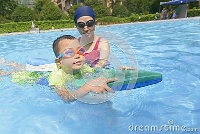 Mom teaching son learn to swim in summer Stock Photo