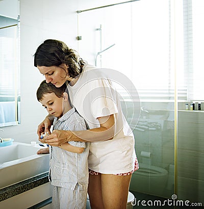 Mom Teaching Son Use Toothbrush in the Toilet Stock Photo