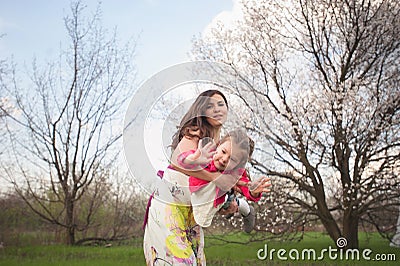 Mom throws daughter plays on the background of blue sky Stock Photo