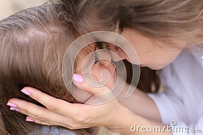 Mom touches the face of her little daughter Stock Photo