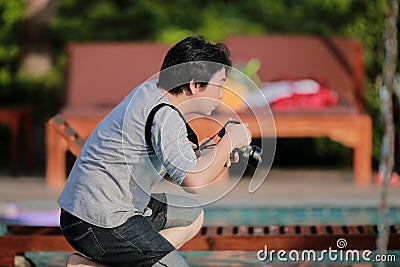 The moment of Asian Thai Professional photographer is kneeling and wating for take a great photo Stock Photo