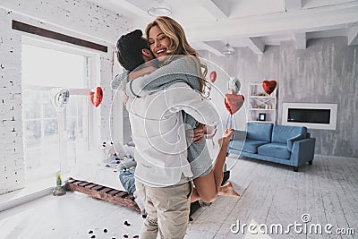 Moments of intimacy. Beautiful young couple embracing and smiling while spending time in the bedroom Stock Photo