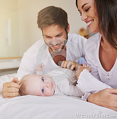 Mommy and daddy love me. a young couple and their baby daughter in the bedroom. Stock Photo