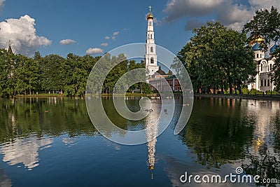 Monastery pond with swans and reflection of tower of the Nikolo-Ugreshsky Monastery of the Russian Orthodox Church Stock Photo