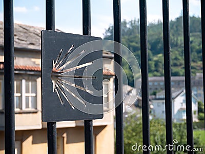 MONDONEDO, SPAIN - AUGUST 14, 2022:Scallop shell Way of St James route sign carved on the metallic fence in the old town Mondonedo Editorial Stock Photo