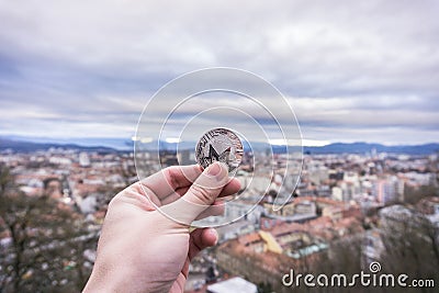 Monero silver coin, Hand hold Monero above the city Editorial Stock Photo