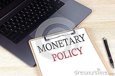 MONETARY POLICY text written on a paper clipboard on laptop Stock Photo