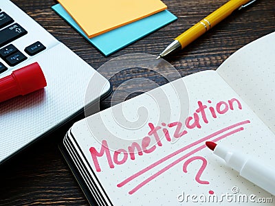 Monetization and question mark on notepad page and notebook. Stock Photo