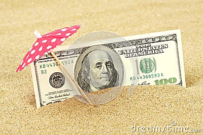 Money american hundred dollar bills in the beach sand under red and white dots sunshade Stock Photo