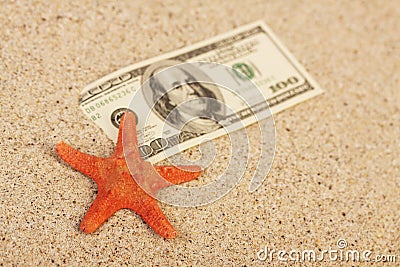 Money american hundred dollar bills in sand and red orange star fish Stock Photo