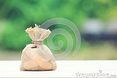 Money bag attached to the plaster on natural green background,Saving money for Medical expenses and Health care concept Stock Photo