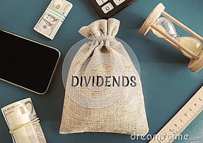 Money bag with the word Dividends. Payment made by a corporation to its shareholders as a distribution of profits. Concept Stock Photo