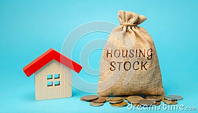 A money bag with the word Housing stock and a miniature house. Residential buildings and premises intended for permanent residence Stock Photo