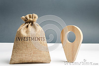Money bag with the word Investments and a geolocation marker. Point and direct investments in a region or country. Construction of Stock Photo