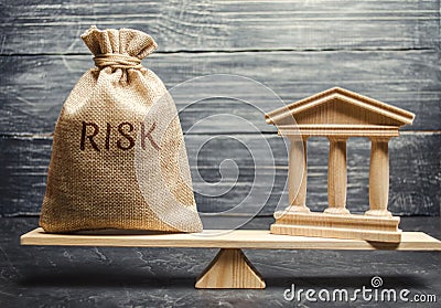 A money bag with the word Risk and a bank building on the scales. The concept of financial and economic risk. Unreliable Stock Photo