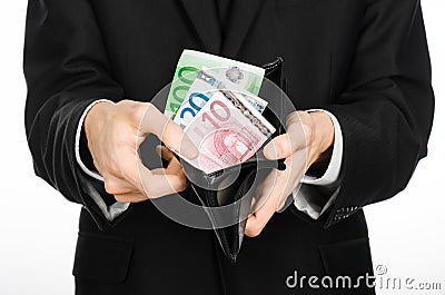 Money and business theme: a man in a black suit holding a purse with paper money Euro isolated on white background in studio Stock Photo