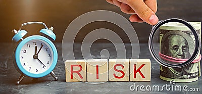 Money, clock and wooden blocks with the word Risk. The concept of financial risk. Justified risks. Investing in a business project Stock Photo