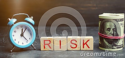 Money, clock and wooden blocks with the word Risk. The concept of financial risk. Justified risks. Investing in a business project Stock Photo