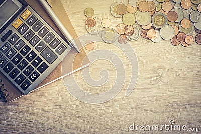 Money coins, calculator and some stationery on wood table Editorial Stock Photo